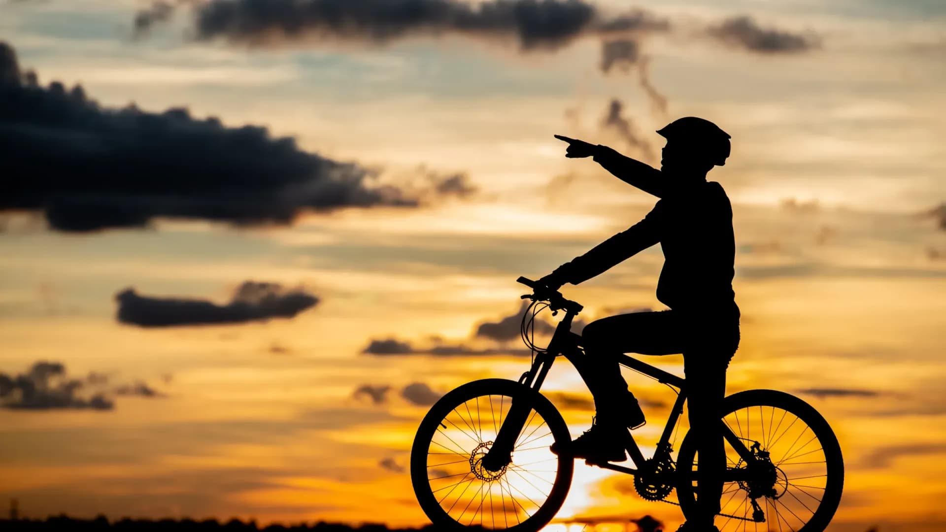 Radurlaub auf Mallorca: Radfahrer zeigt in den Sonnenuntergang