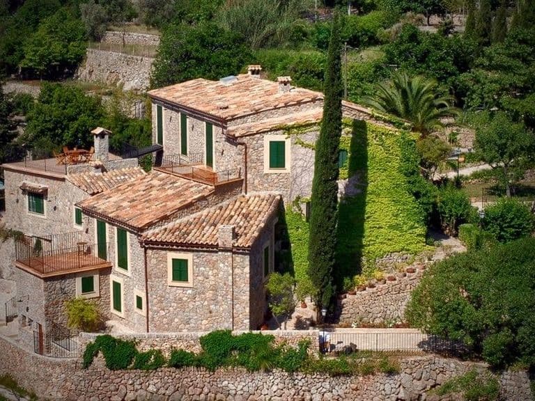 Petra auf Mallorca mit dem Rad: steinerne Finca mit Zypressen und Garten bei Petra