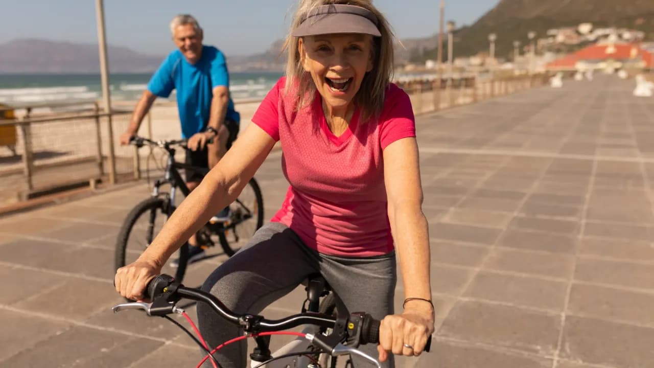 Genussradeln auf Mallorca: Paar auf Trekkingrädern an der Strandpromenade