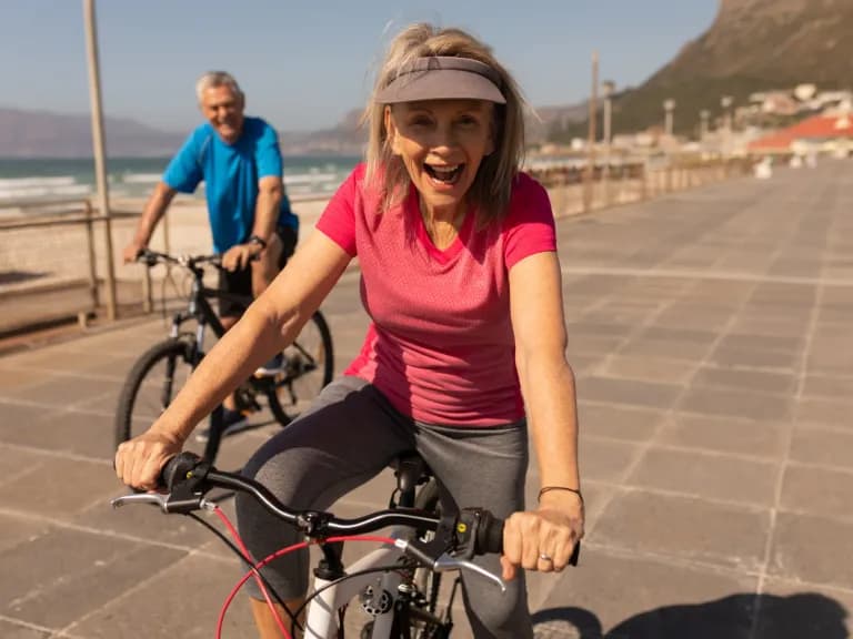 Genussradeln auf Mallorca: Paar auf Trekkingrädern an der Strandpromenade