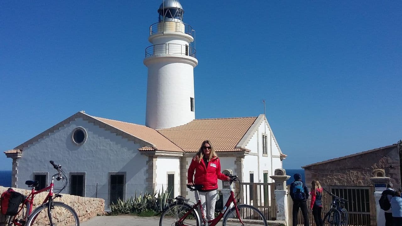 Radfahrer-Gruppe am Leuchtturm an der Ostküste Mallorcas